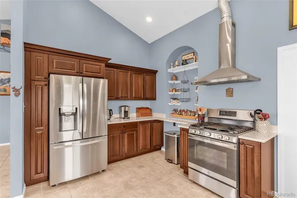 a kitchen with stainless steel appliances granite countertop a stove a sink dishwasher and cabinets with wooden floor