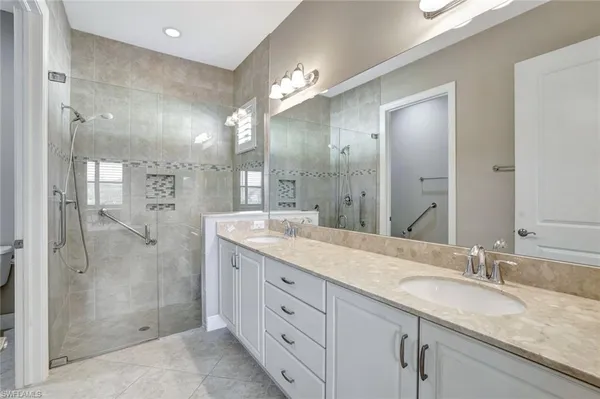 a bathroom with a granite countertop sink mirror and shower
