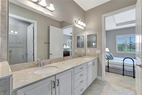 a spacious bathroom with a granite countertop sink mirror and shower