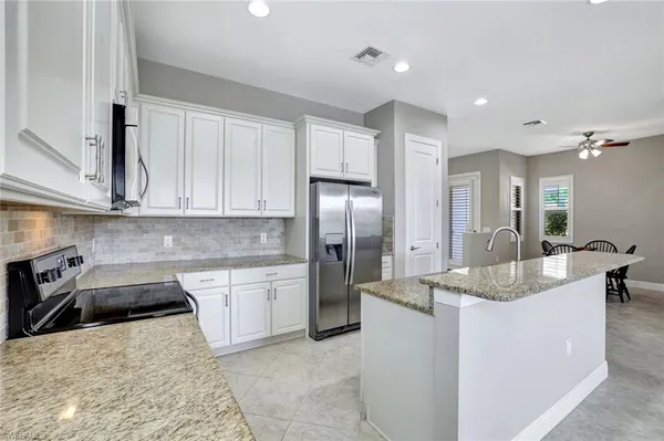 a kitchen with stainless steel appliances granite countertop a sink a stove and a refrigerator
