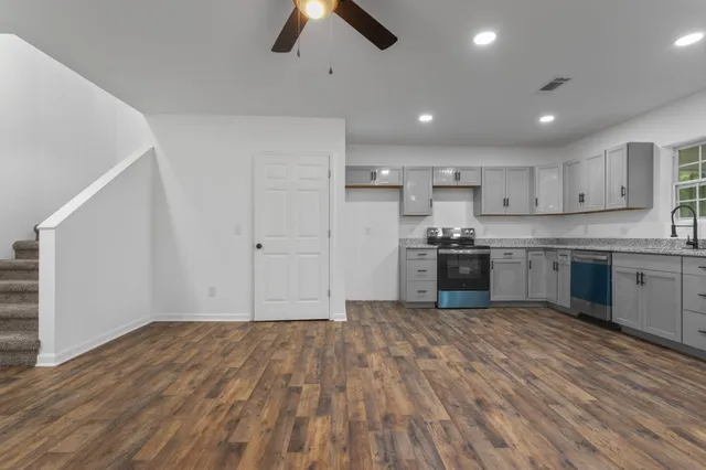a view of kitchen with stove top oven and cabinets