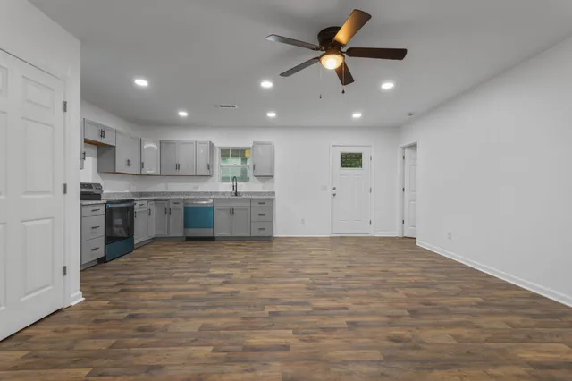 a kitchen with granite countertop a sink stainless steel appliances and cabinets