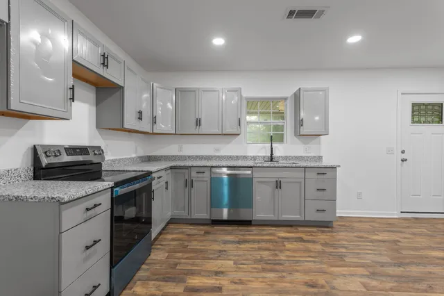 a kitchen with stainless steel appliances granite countertop a sink stove and refrigerator