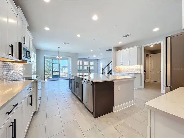 a kitchen with stainless steel appliances granite countertop a sink and a stove