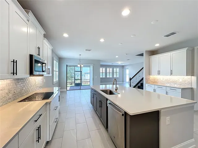 a kitchen with granite countertop white cabinets and stainless steel appliances