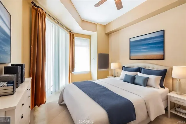 a bedroom with a bed a flat screen tv and next to a window