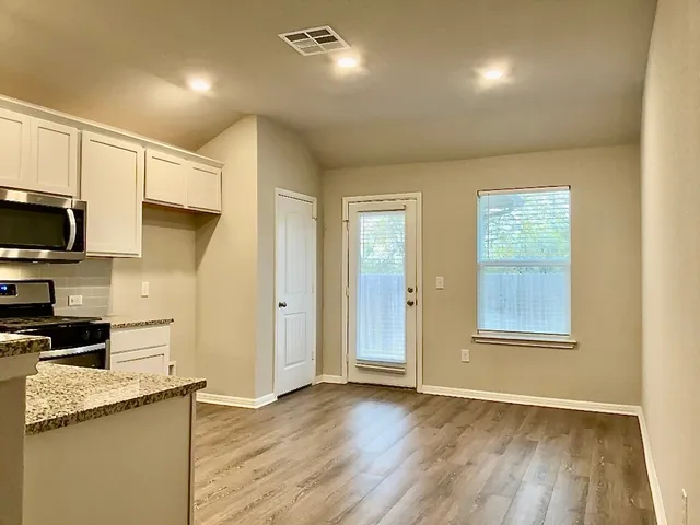 a kitchen with white cabinets and black appliances