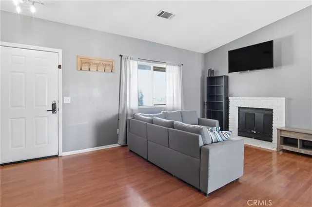 a living room with furniture a flat screen tv and a fireplace