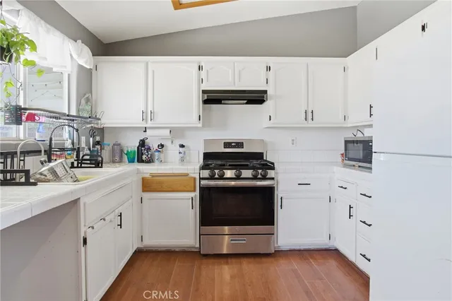 a kitchen with stainless steel appliances white cabinets and a sink