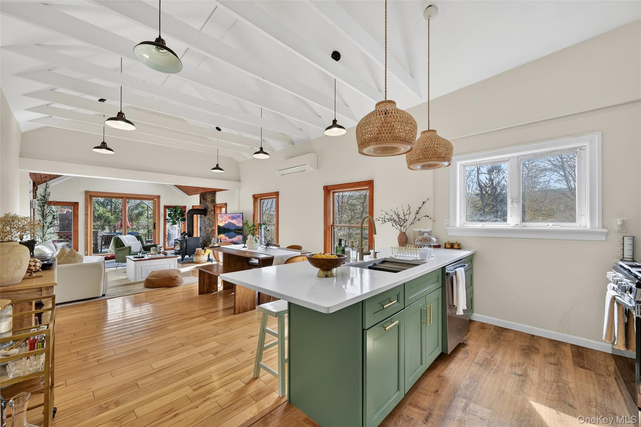 96 Lower Wisner Road Warwick, NY 10990 - Photo 8 of 34 Open-concept living space featuring vaulted ceilings with exposed beams, wood-finish flooring, and a kitchen island with a light green finish and white countertop