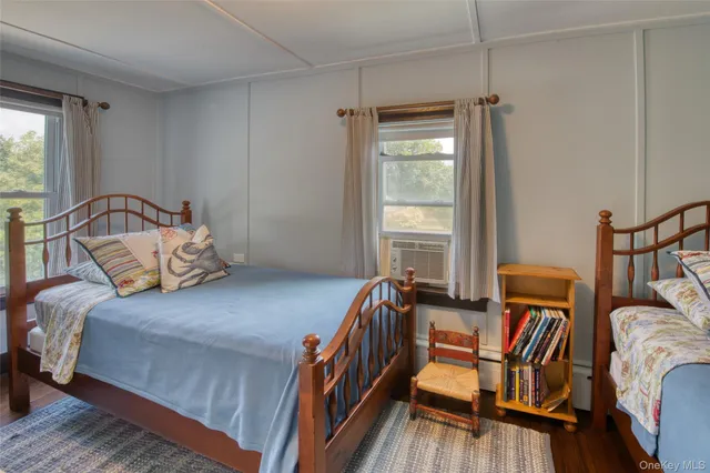 a bedroom with two beds and large windows