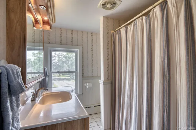 a bathroom with a sink a mirror and a shower