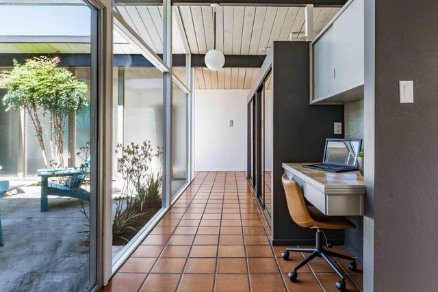 a room with a chair and potted plant with view of living room