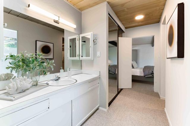 a en suite bathroom with a granite countertop sink and a mirror