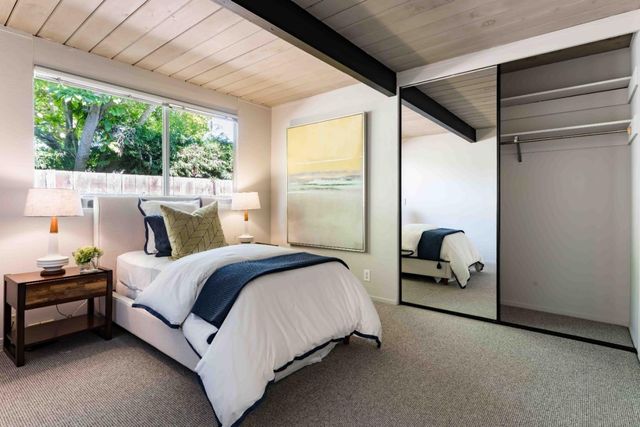 a bed sitting in a bedroom next to a window