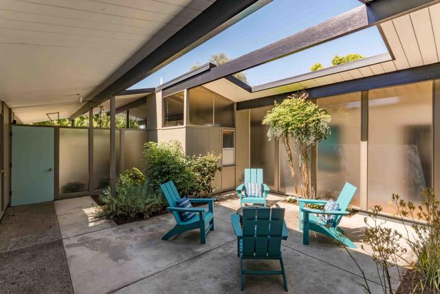 a view of a house with backyard and sitting area