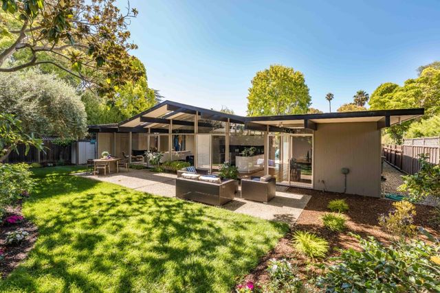 a view of a patio with table and chairs under an umbrella