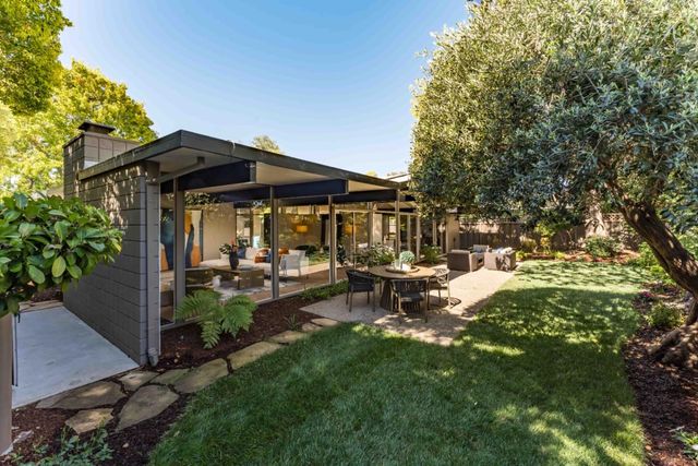 a view of an outdoor dining space with a table and chairs