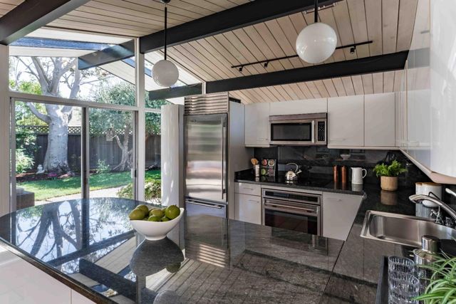 a open kitchen with stainless steel appliances granite countertop a sink a stove top oven a counter space and cabinets