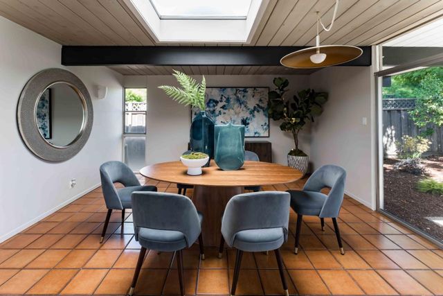 a dining room with furniture and a large window