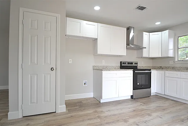 a kitchen with granite countertop white cabinets and white appliances