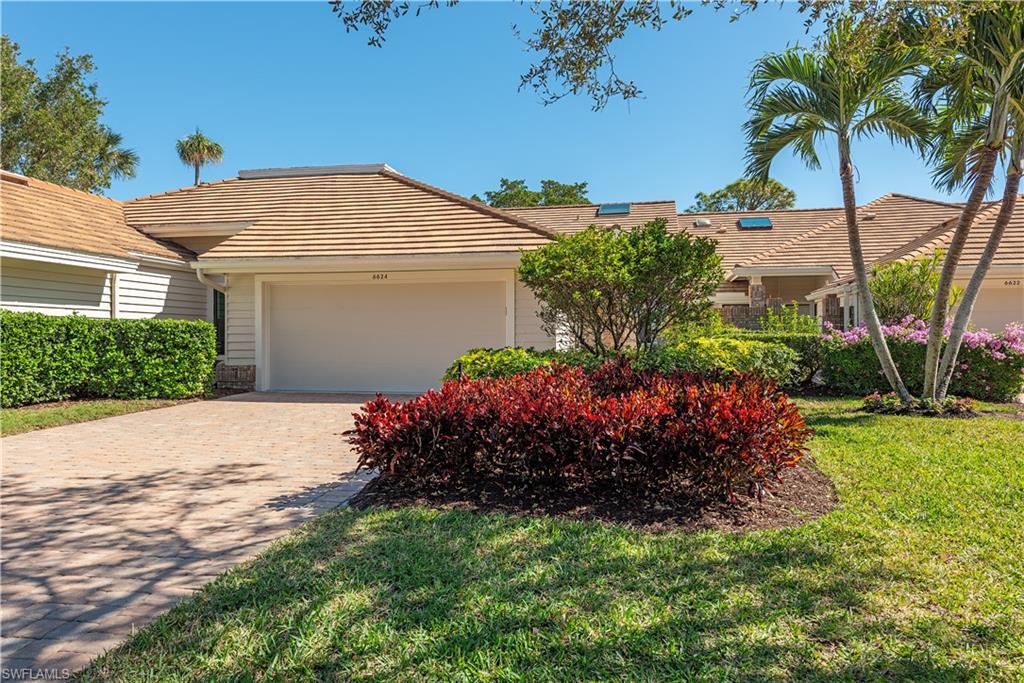 6624 Trident Way, Unit G5 Naples, FL 34108 - Photo 2 of 18 a view of a house with a yard and potted plants