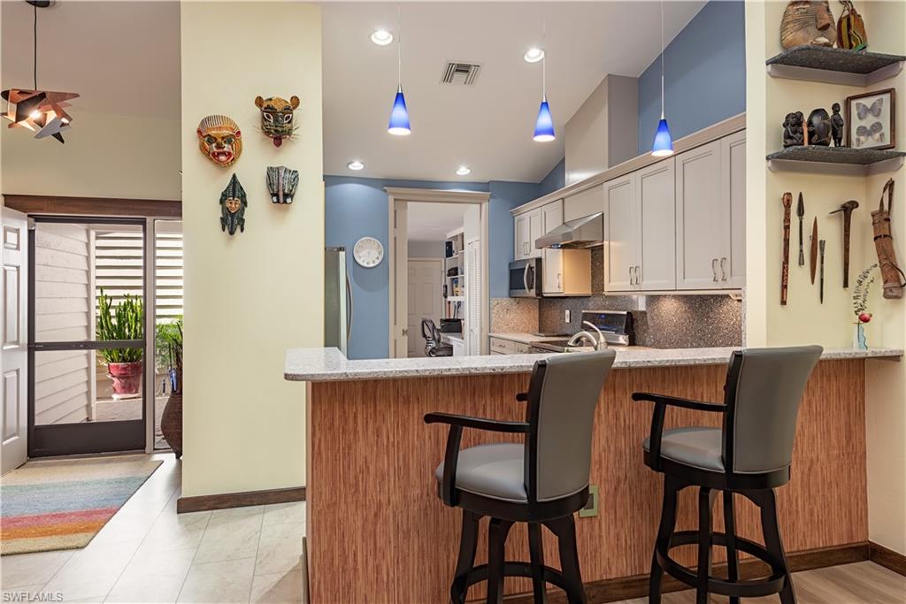 6624 Trident Way, Unit G5 Naples, FL 34108 - Photo 7 of 18 a kitchen with stainless steel appliances granite countertop a table chairs refrigerator and sink