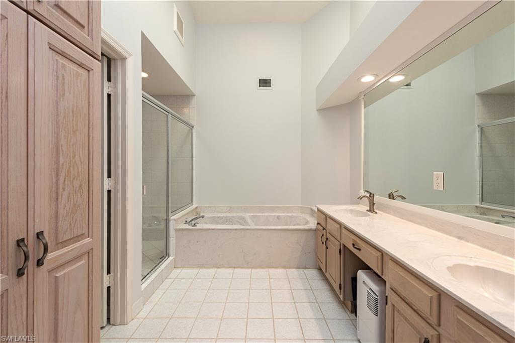 6624 Trident Way, Unit G5 Naples, FL 34108 - Photo 10 of 18 a bathroom with a tub sink and mirror