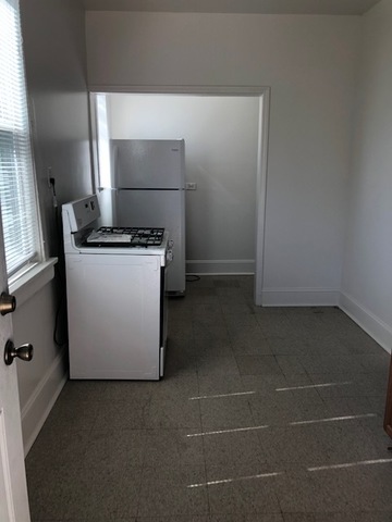 549 East 68th Street, Unit 1 Chicago, IL 60637 - Photo 3 of 8 a kitchen with a stove and a refrigerator
