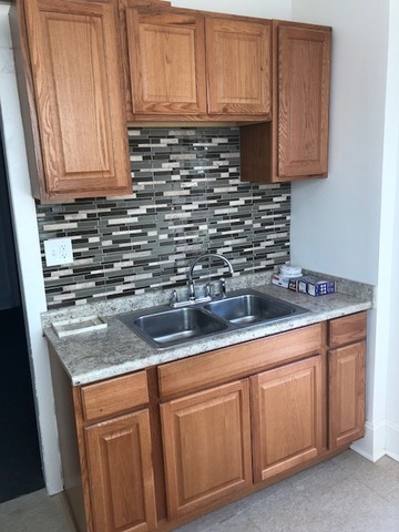 549 East 68th Street, Unit 1 Chicago, IL 60637 - Photo 4 of 8 a kitchen with stainless steel appliances granite countertop a sink a stove and cabinets