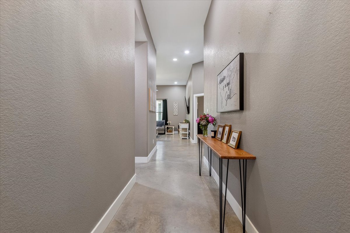 145 Cardinal Loop Paige, TX 78659 - Photo 8 of 40 An inviting entry hallway with durable concrete flooring leads to the home's primary living areas.