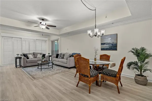 a living room with furniture a chandelier and a potted plant