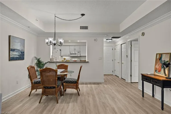 a view of a dining room with furniture a chandelier and wooden floor