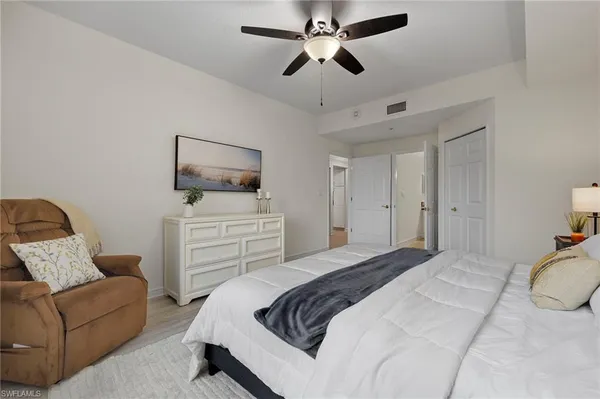 a bedroom with a bed a couch and a flat screen tv
