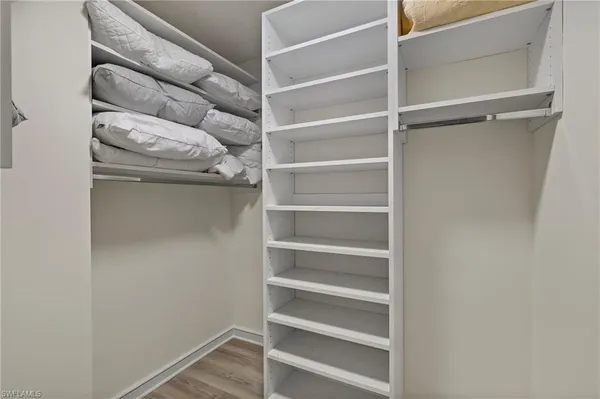 a view of walk in closet with empty racks