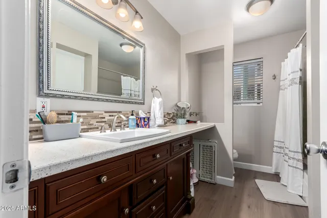 a bathroom with a granite countertop sink a mirror and a shower