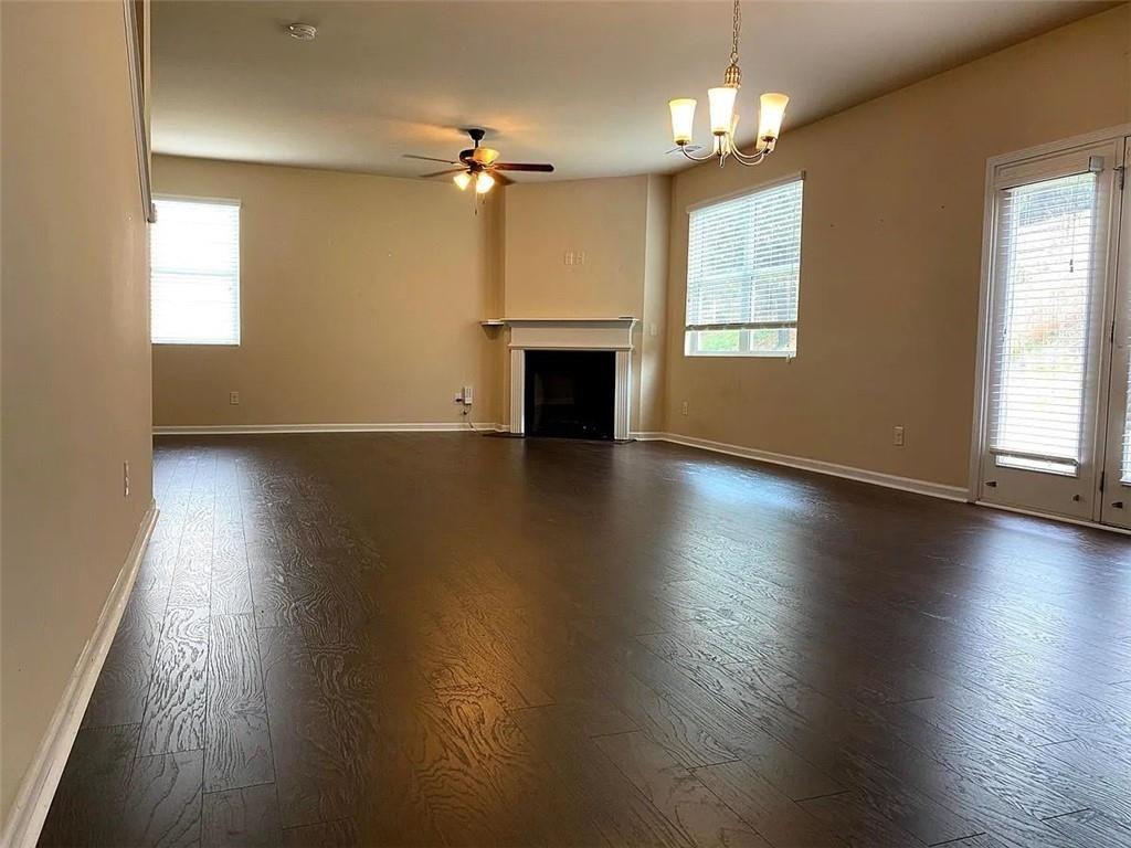 3110 Boxwood Crossing Gainesville, GA 30507 - Photo 2 of 15 an empty room with wooden floor fireplace and windows