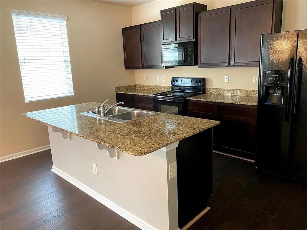 3110 Boxwood Crossing Gainesville, GA 30507 - Photo 3 of 15 a kitchen with granite countertop stainless steel appliances a sink stove refrigerator and a microwave