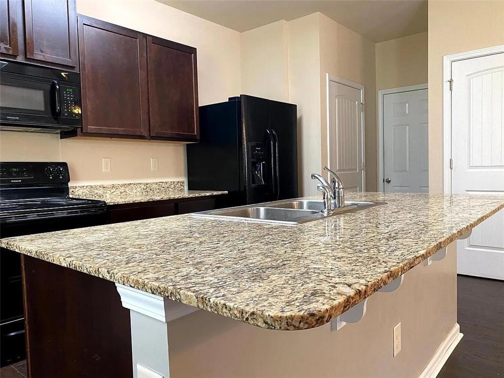 3110 Boxwood Crossing Gainesville, GA 30507 - Photo 5 of 15 a kitchen with kitchen island granite countertop a sink and a refrigerator