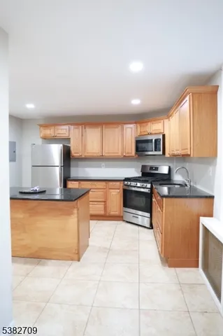 a kitchen with a sink a stove a microwave and refrigerator