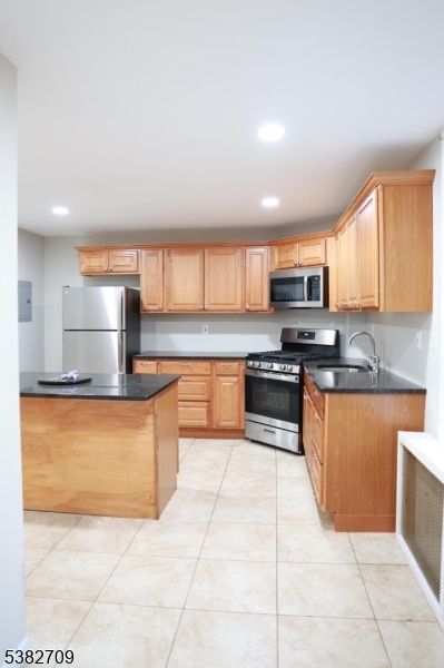 237 Haledon Avenue Haledon, NJ 07508 - Photo 27 of 49 a kitchen with stainless steel appliances granite countertop a stove a sink and a microwave