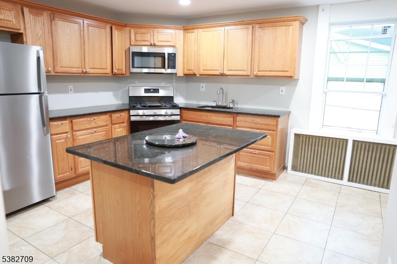 237 Haledon Avenue Haledon, NJ 07508 - Photo 31 of 49 a kitchen with a sink a stove a microwave and refrigerator