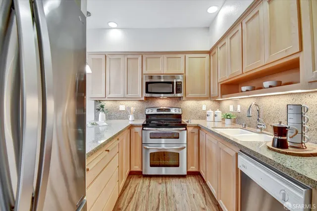 a bathroom with a granite countertop sink a toilet a large mirror a shower and vanity