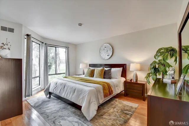 a bedroom with a bed and a lamp on dresser