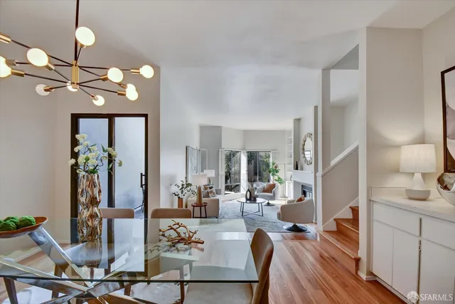 a dining room with furniture a chandelier and wooden floor
