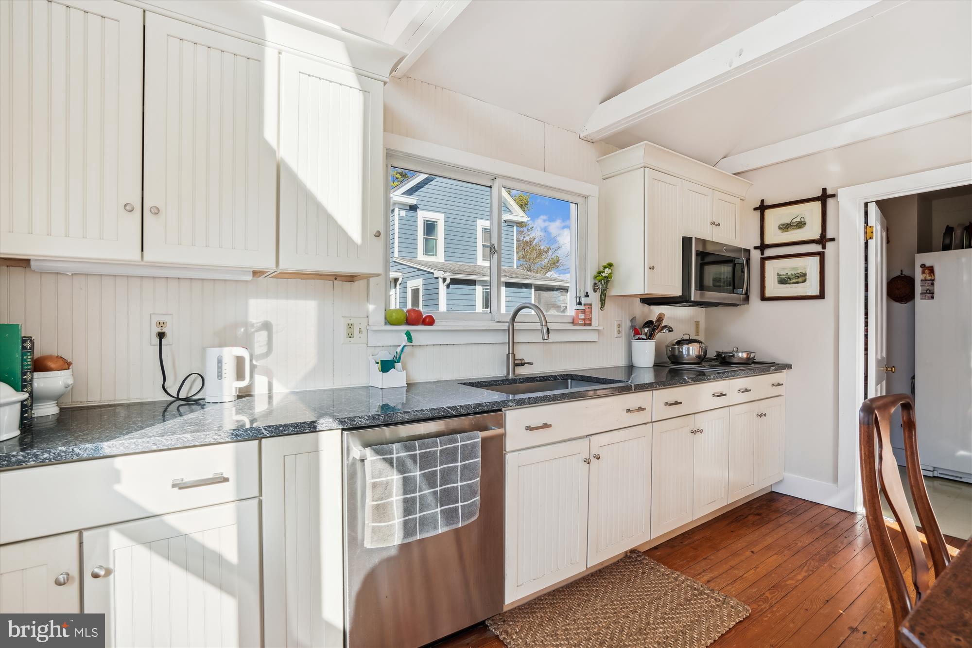 6394 Bozman Neavitt Road Neavitt, MD 21652 - Photo 11 of 26 a kitchen with granite countertop a sink stainless steel appliances and white cabinets