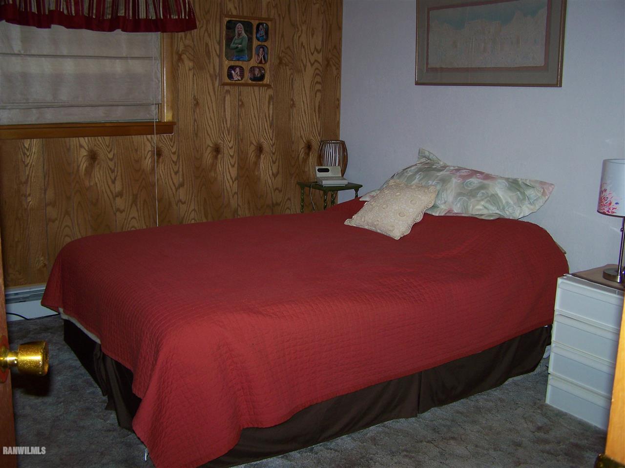 9554 Preston Road Mount Carroll, IL 61053 - Photo 14 of 17 a bed sitting in a bedroom next to a wall