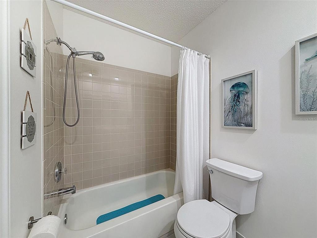 9981 Eagles Point Circle, Unit 4 Port Richey, FL 34668 - Photo 9 of 32 a bathroom with a toilet and a shower