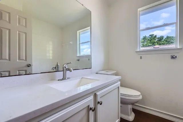 a bathroom with a sink a toilet and a window
