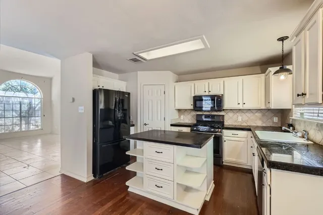a kitchen with stainless steel appliances granite countertop a refrigerator stove and sink